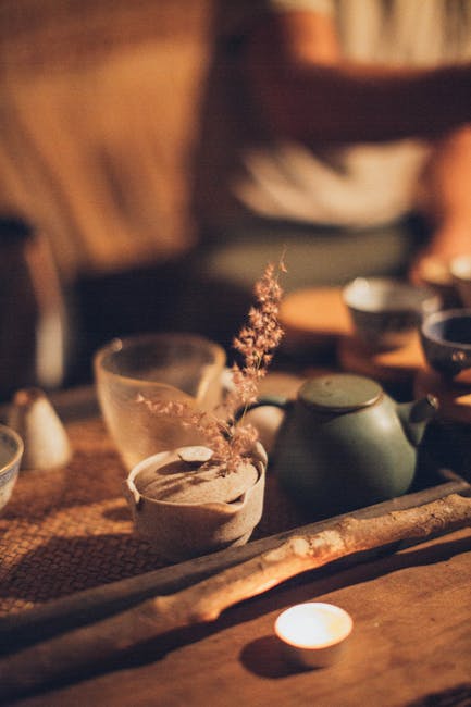 Warm and inviting traditional tea setup with candlelit ambiance, highlighting ceramic tea cups and teapot.